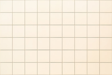 Decorative square beige tile on the facade of the building as a background or backdrop