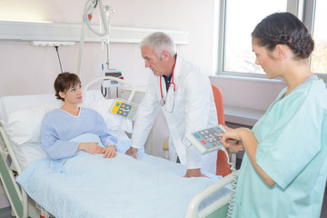 Obraz premium Nurse holding controls for patient's bed