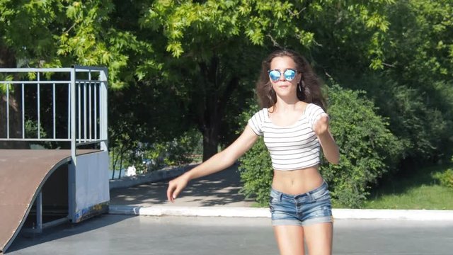 Beautiful girl roller-skating. Girl in sunglasses on roller skates.