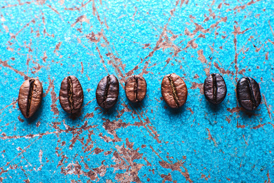 Roasted coffee beans on blue background.