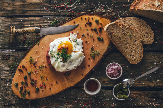 Beef Tatar With Fried Egg On Wooden Board From Above