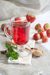 Hot strawberry drink with fresh mint in a glass cup..