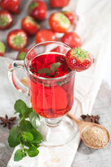 Freshly brewed cup of strawberry tea with fresh mint..