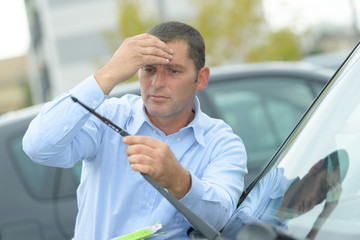 middle-aged man working on windshield wipers