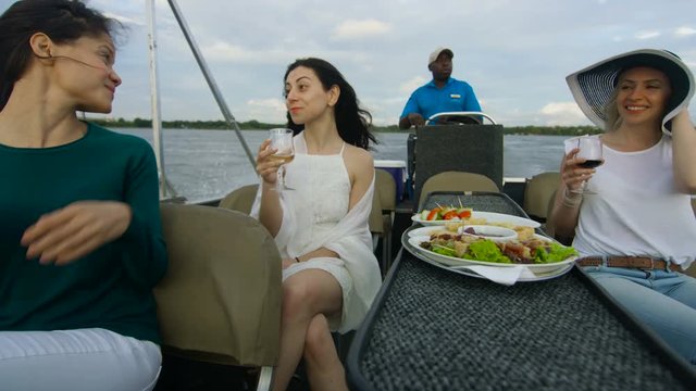  Friends on African vacation drinking wine on boat trip on Zambezi river