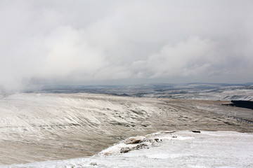 Mountain path in the snow with cold and dangerous walking conditions on Brecon Beacons National Park - Wales.