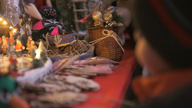 Close-up of a gift shop at Christmas. The buyer chooses a gift, to touch the crafts
