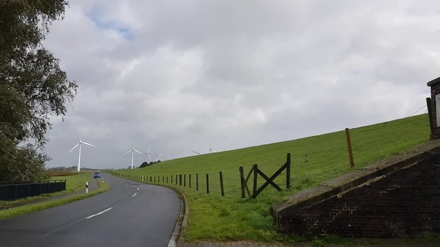 Emden Strasse auto am deich mit Windkraftanlage