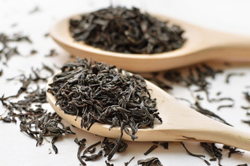 black tea in wooden spoons