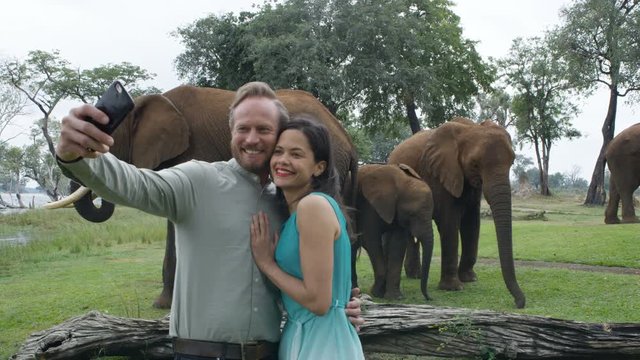  Happy couple on African vacation pose for selfie at wild elephant nature rese