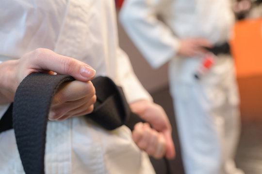 close-up of fighter tightening karate belt