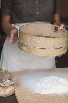 Woman hands sifting flour for baking