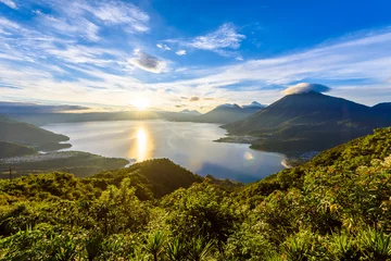 Fotobehang Sunrise in the morning at lake Atitlan, Guatemala - amazing panorama view to the volcanos San Pedro, Toliman and Atitlan © Simon Dannhauer