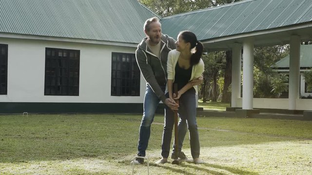 Happy couple on African vacation playing croquet in the hotel gardens
