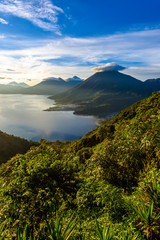 Fototapeta na wymiar Sunrise in the morning at lake Atitlan, Guatemala - amazing panorama view to the volcanos San Pedro, Toliman and Atitlan