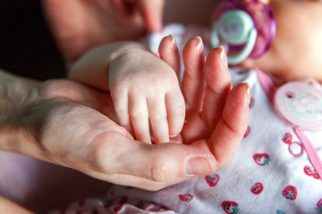 Little baby holding mother's hand
