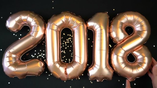 Happy 2018 gold New Year Balloons with glitter stars on black background.