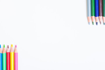 Colored pencils on a light background. The tips of the pencils are positioned in the corners on white background with space for inscriptions. White box for your text with pencils