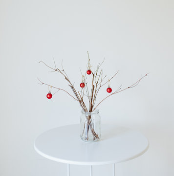 Minimal Holiday Decor Of Branches With Red Ornaments