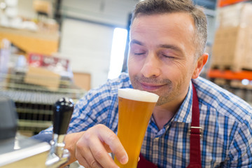 close-up of brewer smelling beer at brewery factory