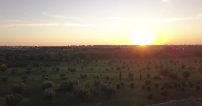 Video from above. Aerial view of the ancient Roman Aqueduct at sunset. Old ruins surrounded by a green public Park. Rome, Italy.