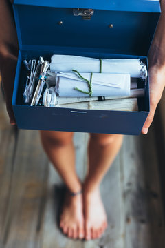 Girl holding an old blue cash tin filled with personal notes and letters
