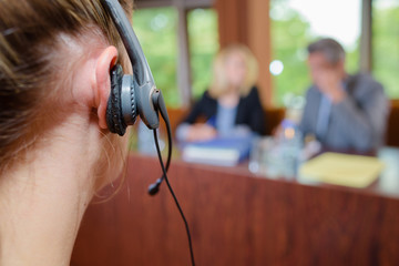 Closeup of woman wearing headset in conference room