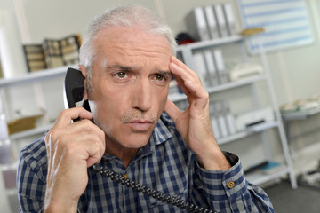 man on telephone, looking concerned