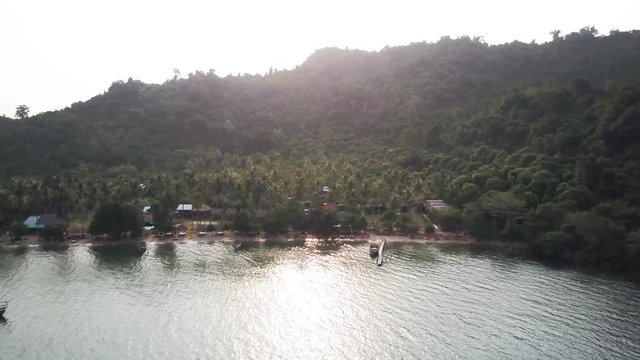 Sunrise on Koh Tonsay, Cambodia as the aerial camera starts from a high altitude and pushes in toward the island.