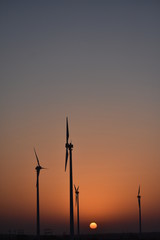 Obraz premium sunrise with modern windmills in thar desert india