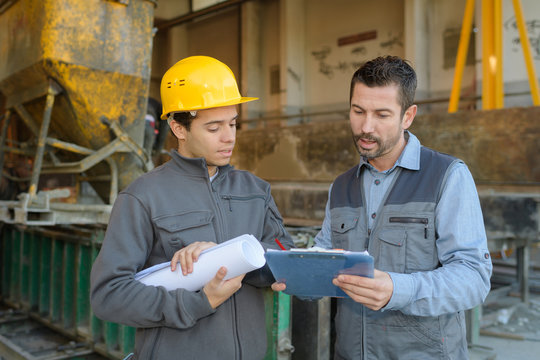 two workers in production plant discussing