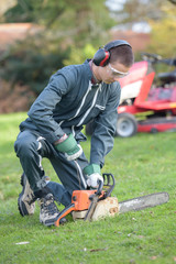 Young man starting chainsaw
