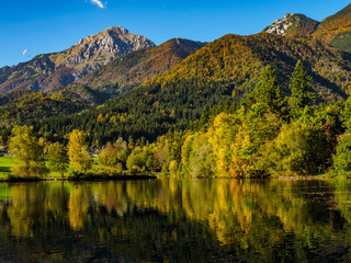 Fototapeta premium Mountains in autumn colors reflecting Lake Crnava by Preddvor, Slovenia