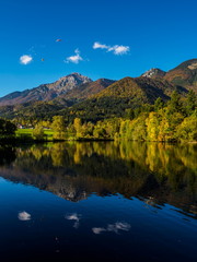 Fototapeta premium Mountains in autumn colors reflecting Lake Crnava by Preddvor, Slovenia