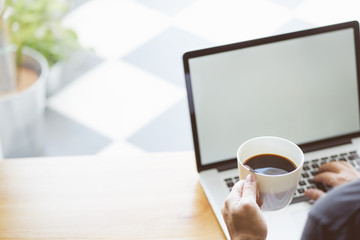 Coffee in businessman hand with Laptop  .