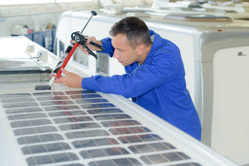 Fitter applying sillicone around solar panel