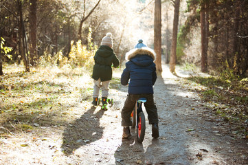 Two little boys doing sports in autumn forest.
