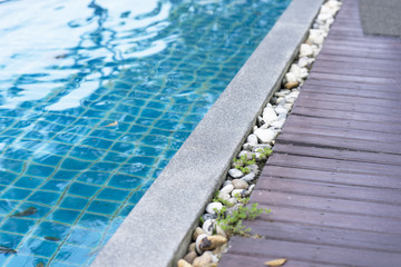 Pool edge with rock and blue water
