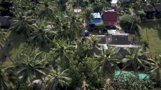 Aerial camera rises quickly and pitches down to show the setting and then the backpacker village on Koh Tonsay, Rabbit Island, Cambodia