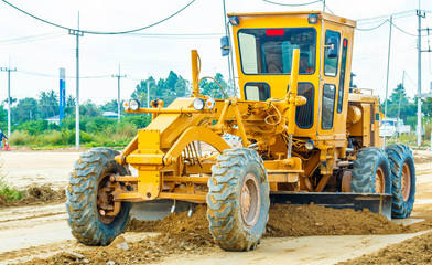 Fototapeta premium Road grader - heavy earth moving road construction equipment