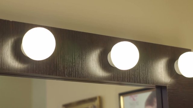 Beautiful mirror with lamps in the beauty salon. Make-up mirror. Dressing room mirror. Barber mirror.