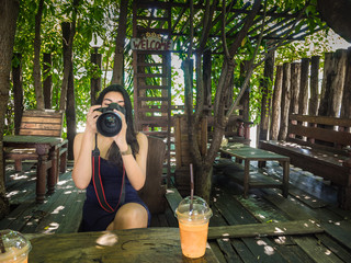 Young woman photographer taking picture in the cafe
