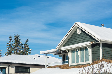 Fototapeta na wymiar Top of residential house in snow on sunny winter day in Canada