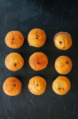 Set of vanilla muffins with chocolate cream filling. Black stone background.