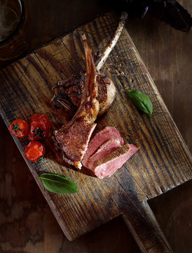 grilled lamb steak with  tomatoes on a wooden background