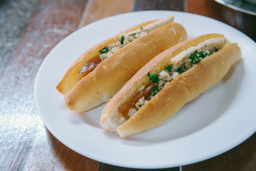 Vietnam Bread stuffed with Chinese sausage and pork on white plate.