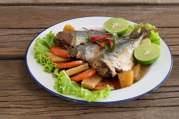 Mackerel boiled sweet and salted on white dish Thai food on old wooden table  .