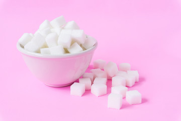 Fototapeta na wymiar Closeup sugar cubes on bowl with pink background, health care concept