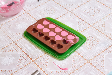 Obraz na płótnie Canvas Melted pink chocolate in hearts shape
