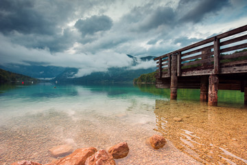 Wooden pier at Bohinj lake on cloudy autumn day